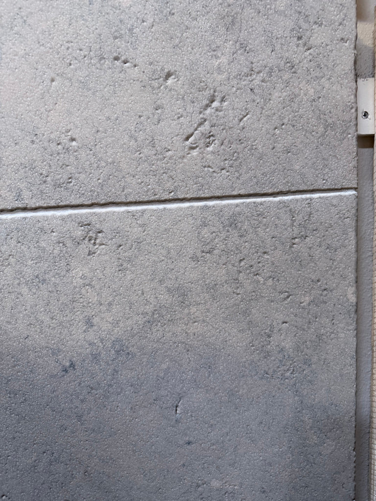 Greyhaven 24x24 honed limestone tiles with gray textured speckled finish and grout lines