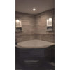 Corner bathtub with tiled surround featuring Hand Made Marble Shampoo Niche