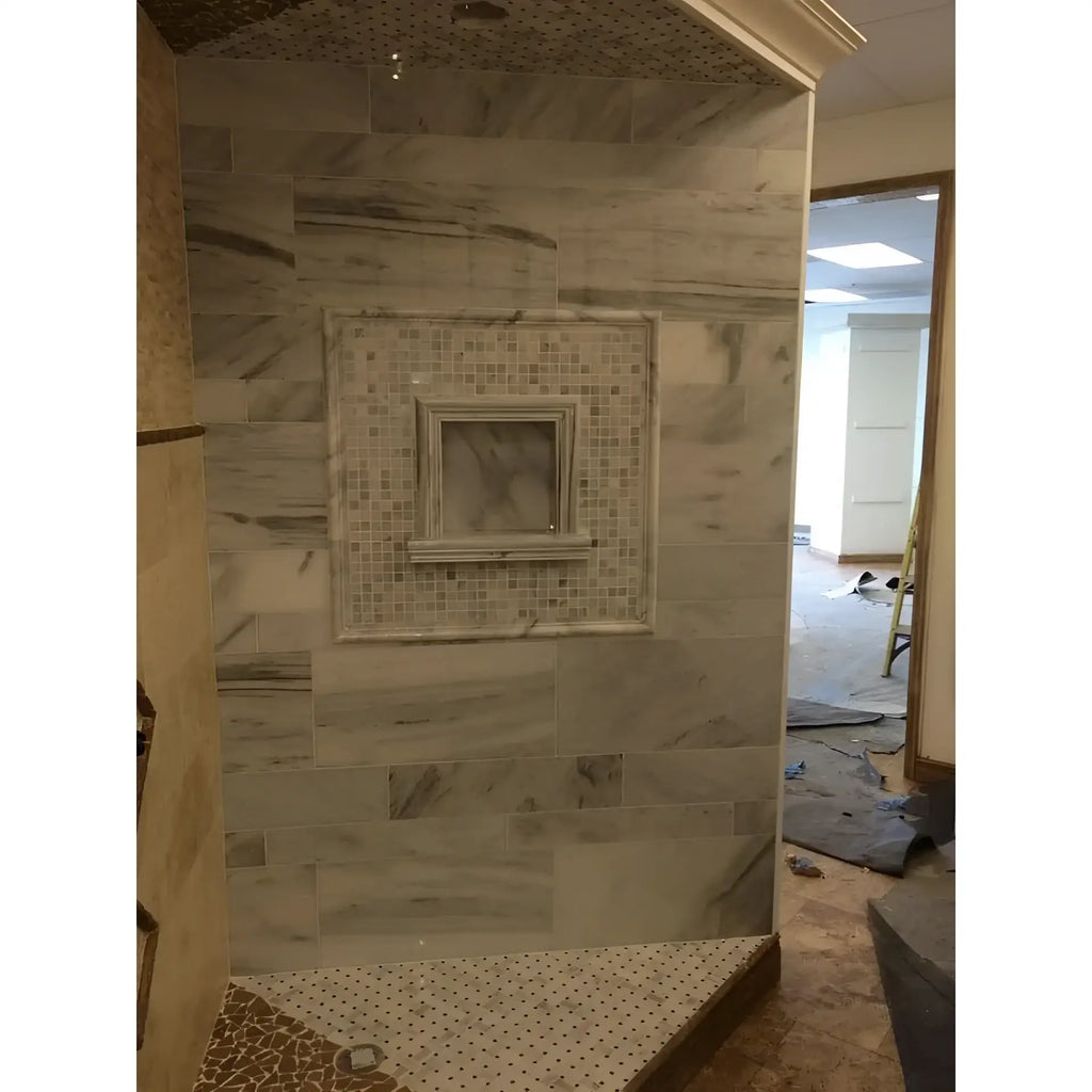 Marble-tiled shower stall featuring Hand Made Marble Shampoo Niche for luxury bathrooms