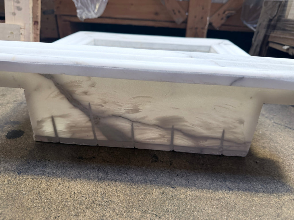 Handmade marble shampoo niche with white soap dish and gray veining