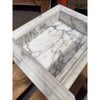 White marble shampoo niche with gray veining and fluted edge detail
