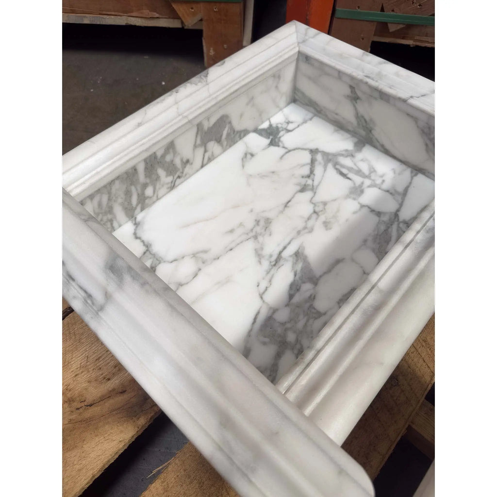 White marble shampoo niche with gray veining and fluted edge detail