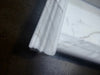 Handmade white marble shampoo niche with ornate fireplace mantel profile