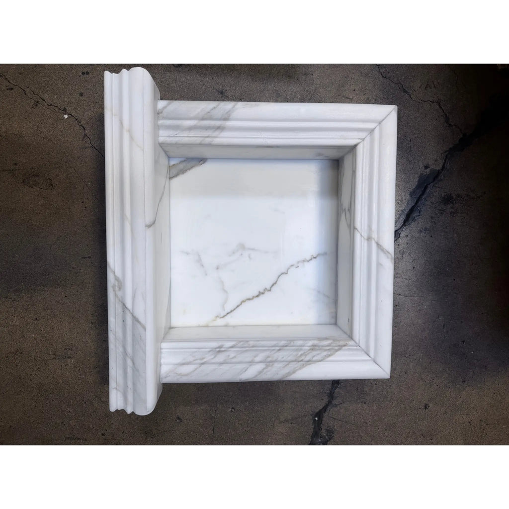 Handmade marble shampoo niche in white frame with fluted edges and gray veining