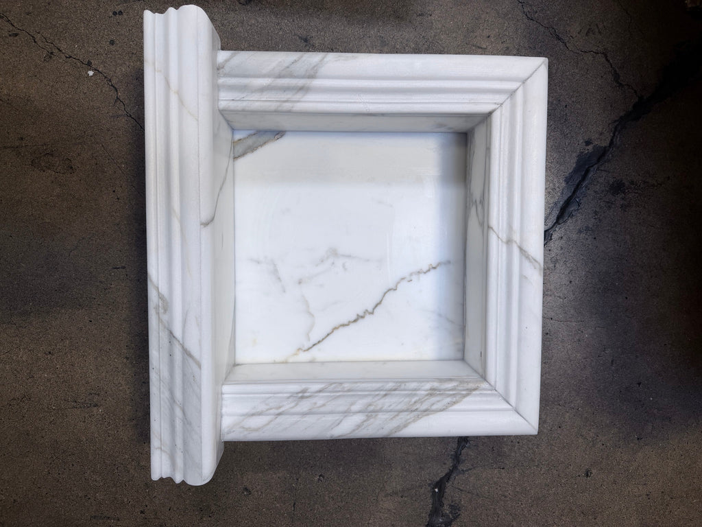 Handmade marble shampoo niche in white frame with fluted edges and gray veining