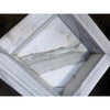 Handmade white marble shampoo niche with gray veining and ribbed border