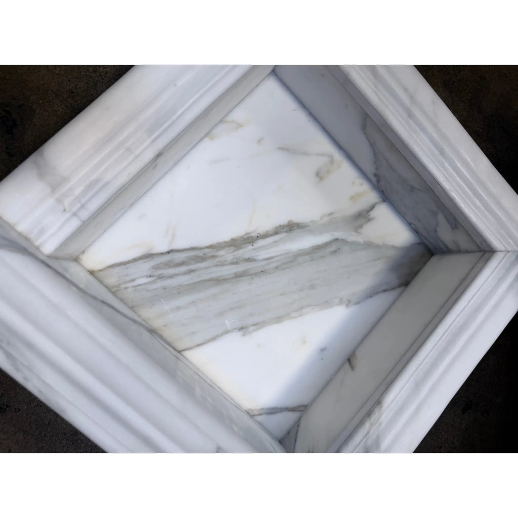 Handmade white marble shampoo niche with gray veining and ribbed border
