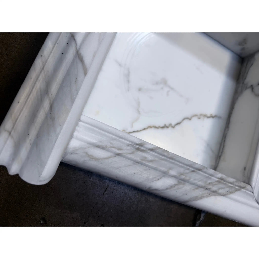 Handmade white marble shampoo niche with elegant veining and ornate rim