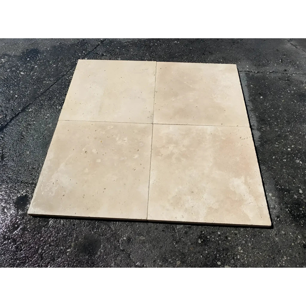 Four beige Ivory Travertine 12X12 Cross-Cut Tumbled tiles arranged in display