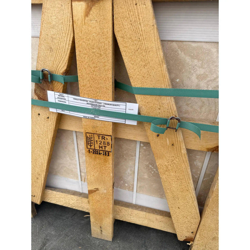Wooden crate with green straps containing Ivory Light Travertine 12x24 tiles