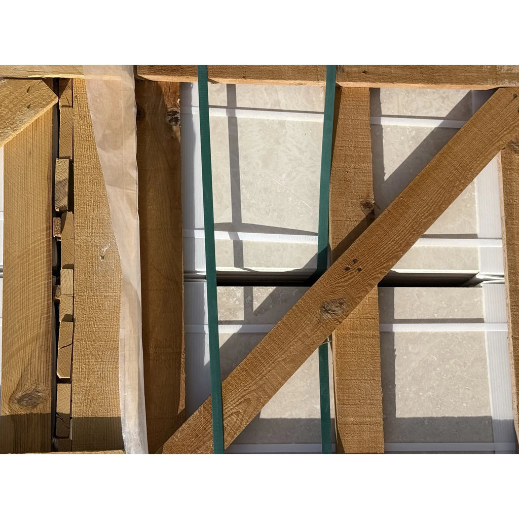 Wooden crate containing Ivory Light Travertine 24X24 Cross-Cut Tumbled tiles