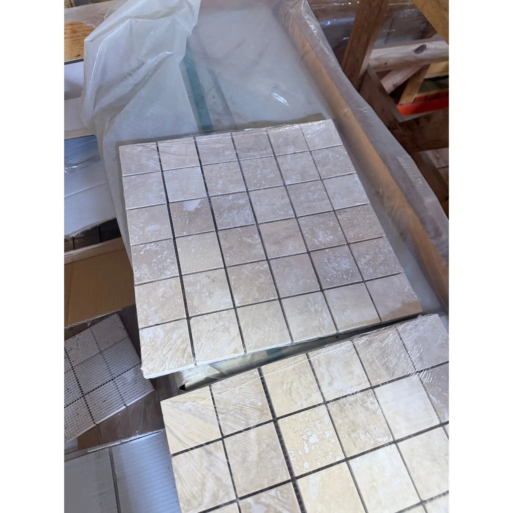 Ivory light travertine 2x2 mosaic tile sheet in beige with subtle veining and square grid honed finish