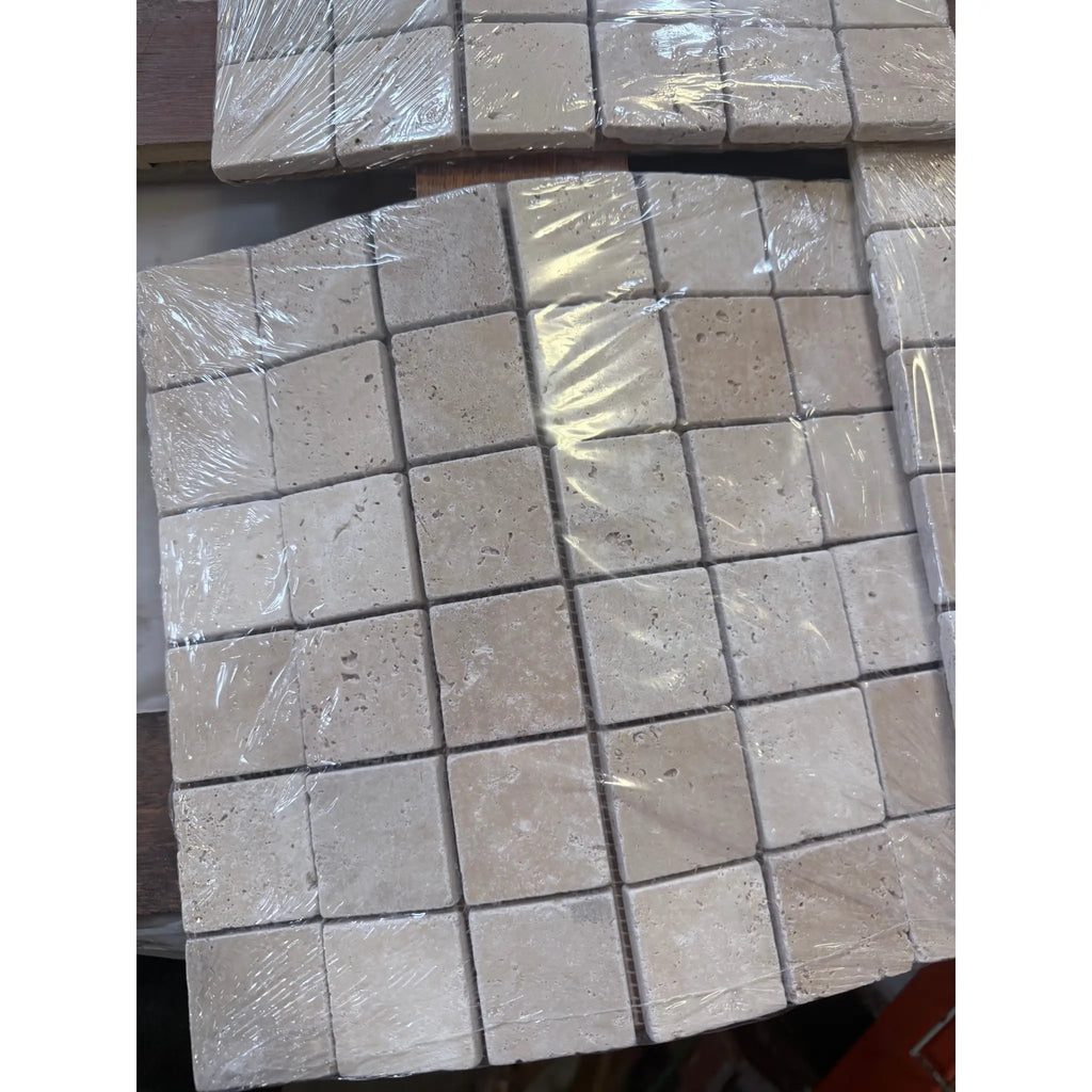 Ivory light travertine 2x2 mosaic tumbled beige square tiles wrapped in clear plastic for wall or floor use