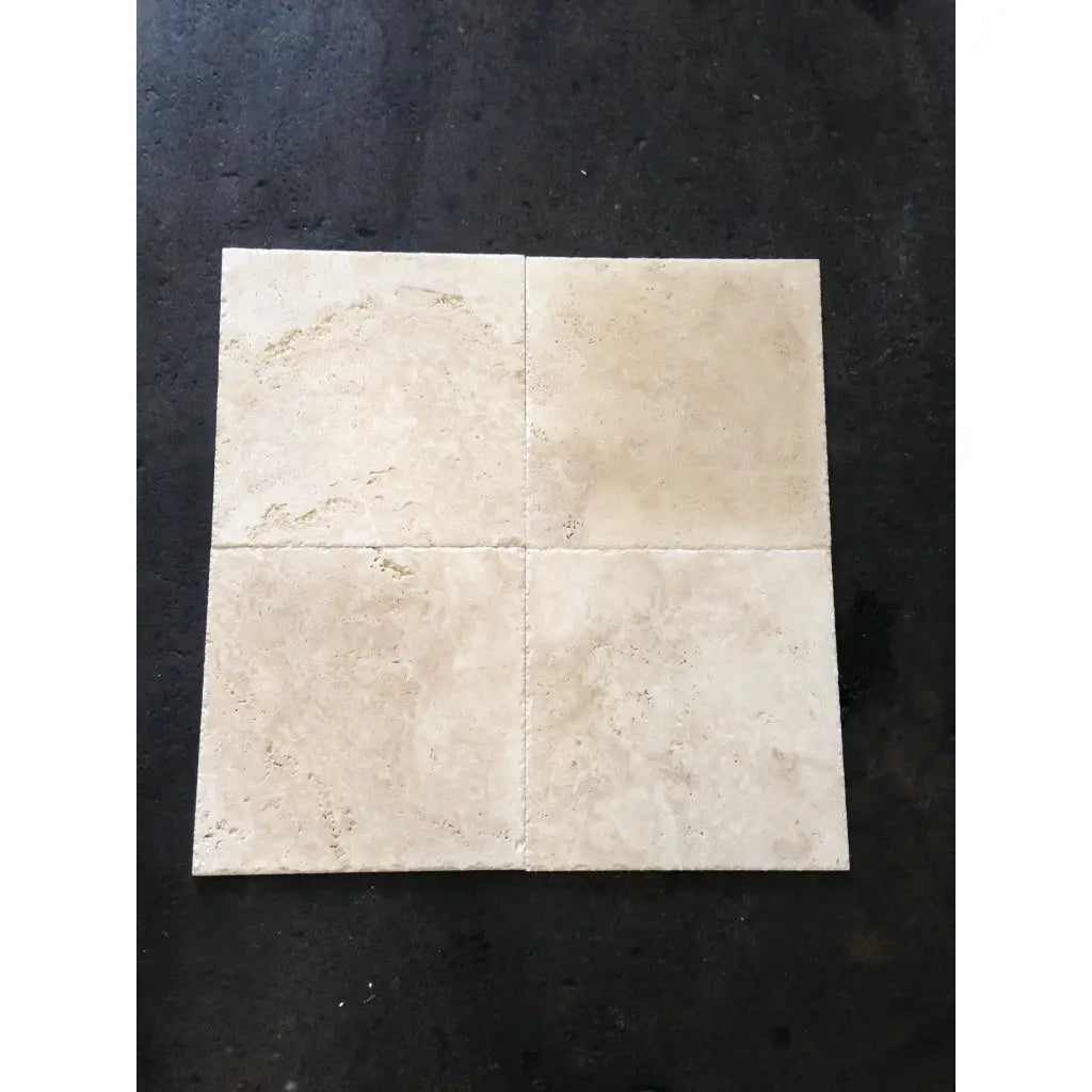 Four beige Ivory Travertine 4X4 cross-cut tumbled tiles showcasing natural beauty
