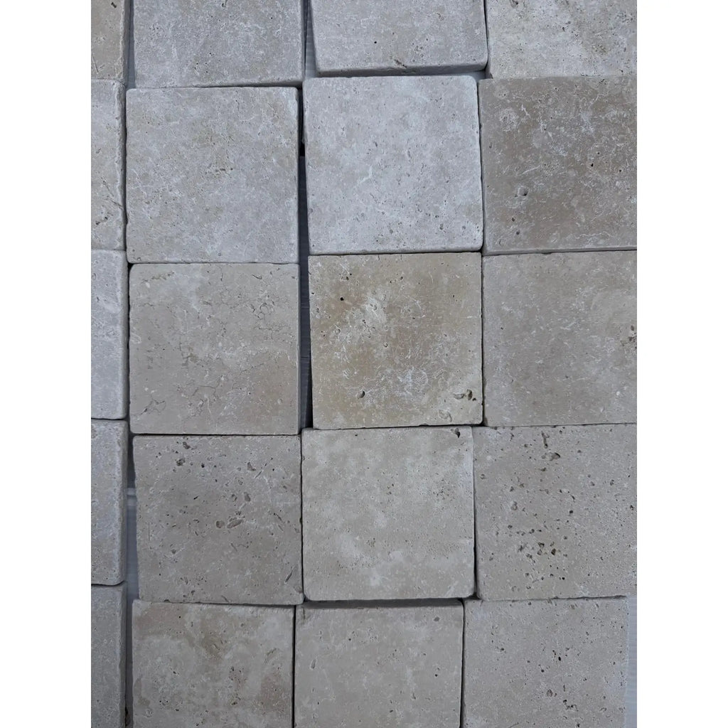 Square ivory travertine tiles in 4x4 cross-cut tumbled finish for elegant flooring