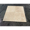 Four beige travertine tiles in Ivory Travertine Octagon with Noce Dots Mosaic Tumbled