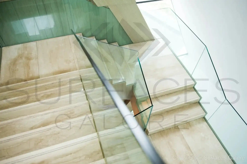 Marble staircase with glass railing.