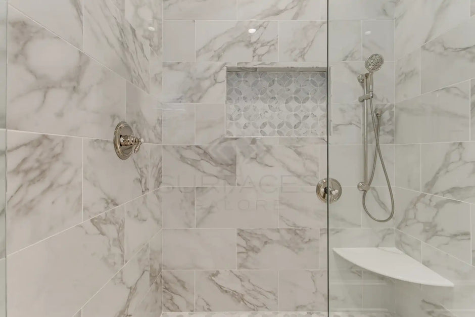 Marble-tiled shower with glass door.
