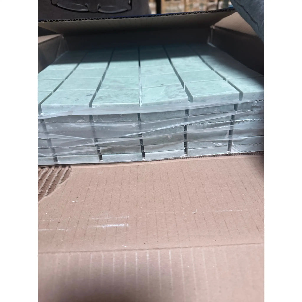 Stack of Ming Green 2x2 mosaic marble tiles in clear plastic wrap
