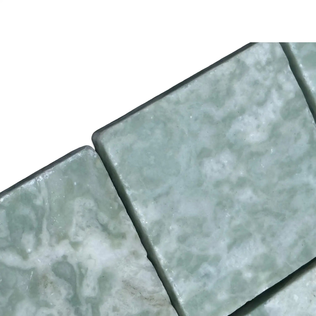 Light green and white marbled square tiles from Ming Green 3x3 Tumbled collection