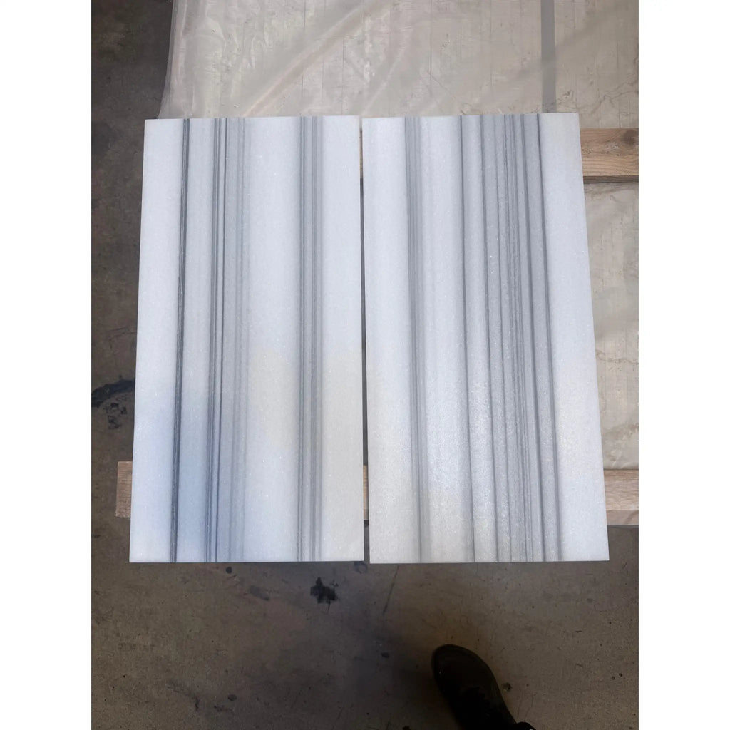 White marble slabs with prominent gray vertical veining in Mink Marmara Equator Zebra Marble 12X12 polished