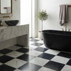 Black freestanding bathtub with gold fixtures in modena bianco dolomite 12x12 and nero marquina 6x12 set