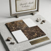 Dark brown spanish marble slabs with golden veining and white bianco dolomite displayed on gray textured stone base