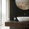 A sleek dark amber glass bottle with black pump and minimalist white label on a nero marquina black marble countertop