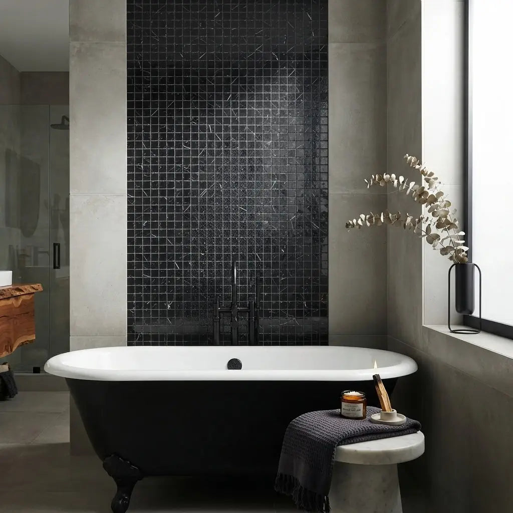 Black clawfoot bathtub with white porcelain rim and chrome fixtures in polished nero marquina black marble mosaic design