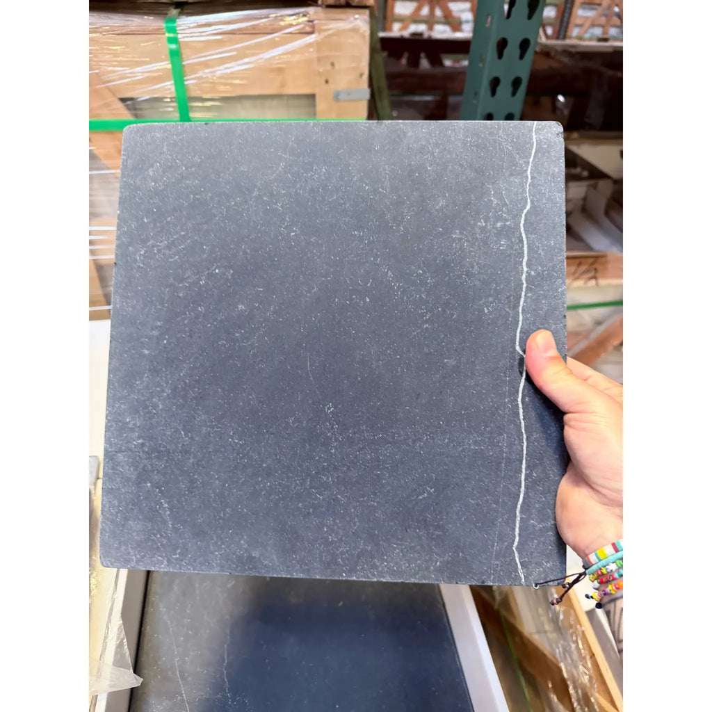 Charcoal gray Nero Marquina marble tile with natural stone texture and white grout