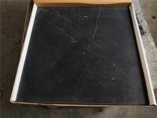 Black Nero Marquina marble coaster set with white veining in a cardboard box