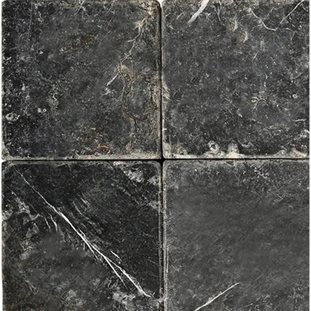Four dark Nero Marquina Black Marble 4X4 Tumbled tiles showcasing elegant design