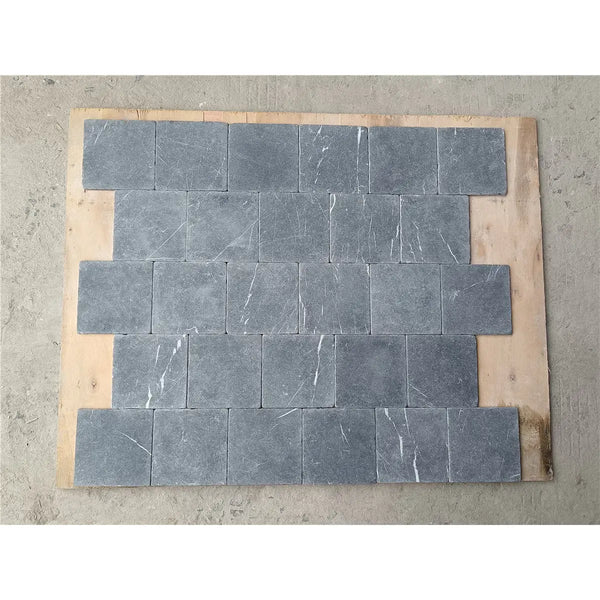 Dark gray nero marquina black marble 4x4 tumbled stone tiles with subtle white veining arranged in staggered pattern