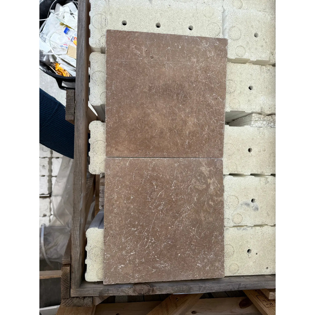 Two Noce Brown Travertine 12X12 Cross-Cut Tumbled marble tiles displayed together