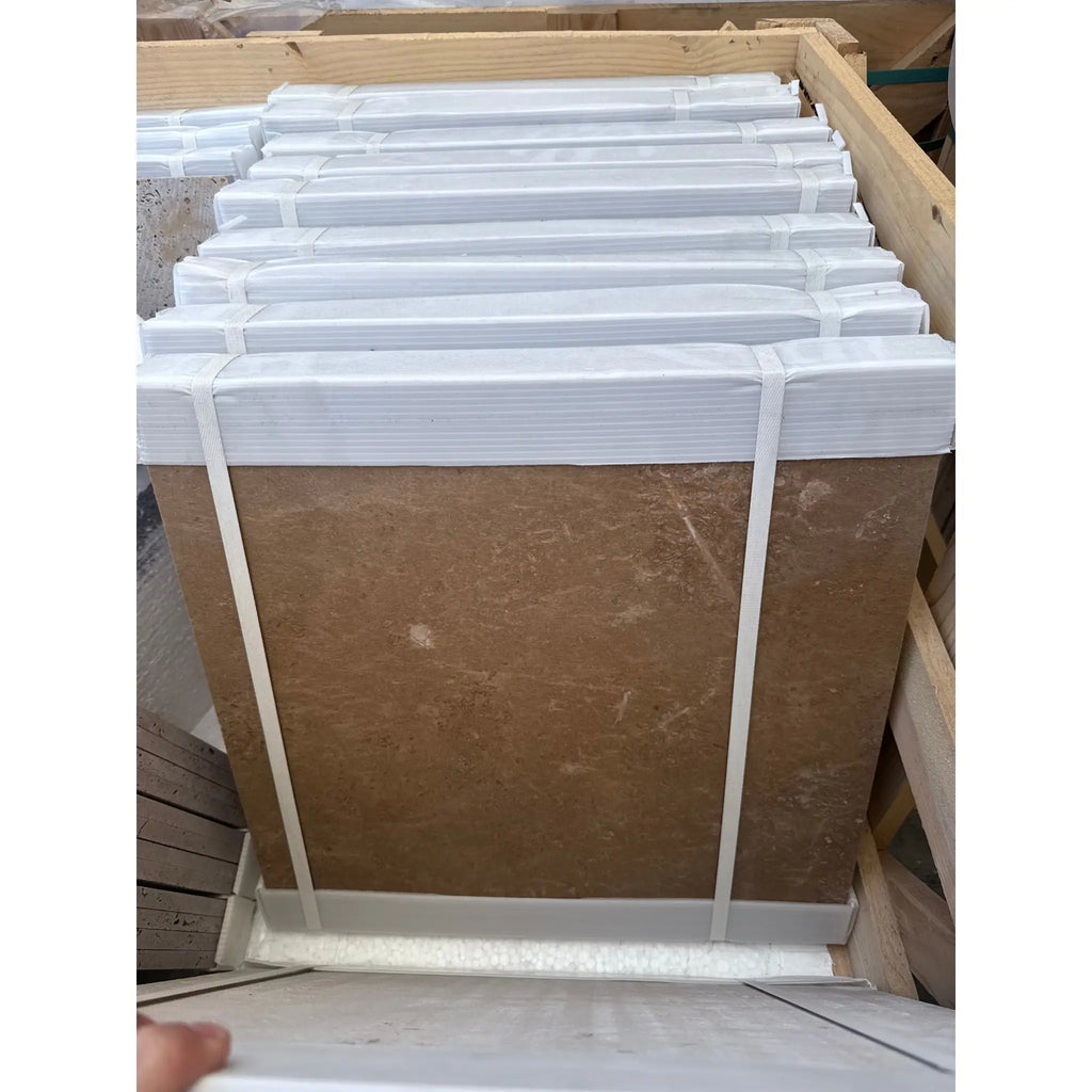 Stacked brown marble slabs from Noce Travertine 18x18 Cross-Cut product