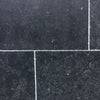 Obsidian Ash 16x24 limestone brushed tiles in dark gray with white speckles and grout