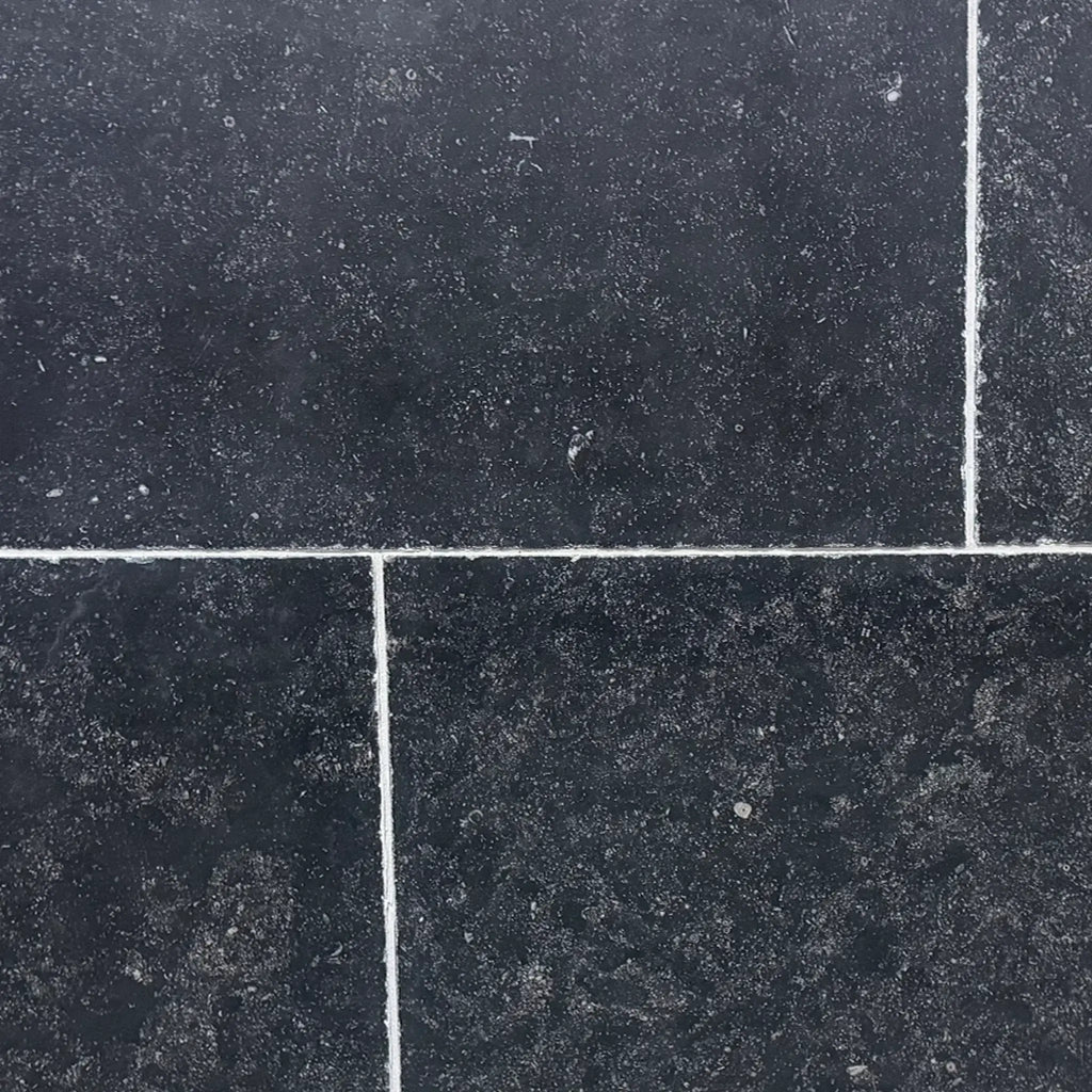 Obsidian Ash 16x24 honed limestone tiles in dark gray with white speckles and grout