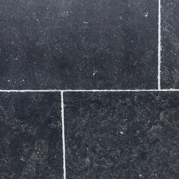 Obsidian Ash 16x24 honed limestone tiles in dark gray with white speckles and grout