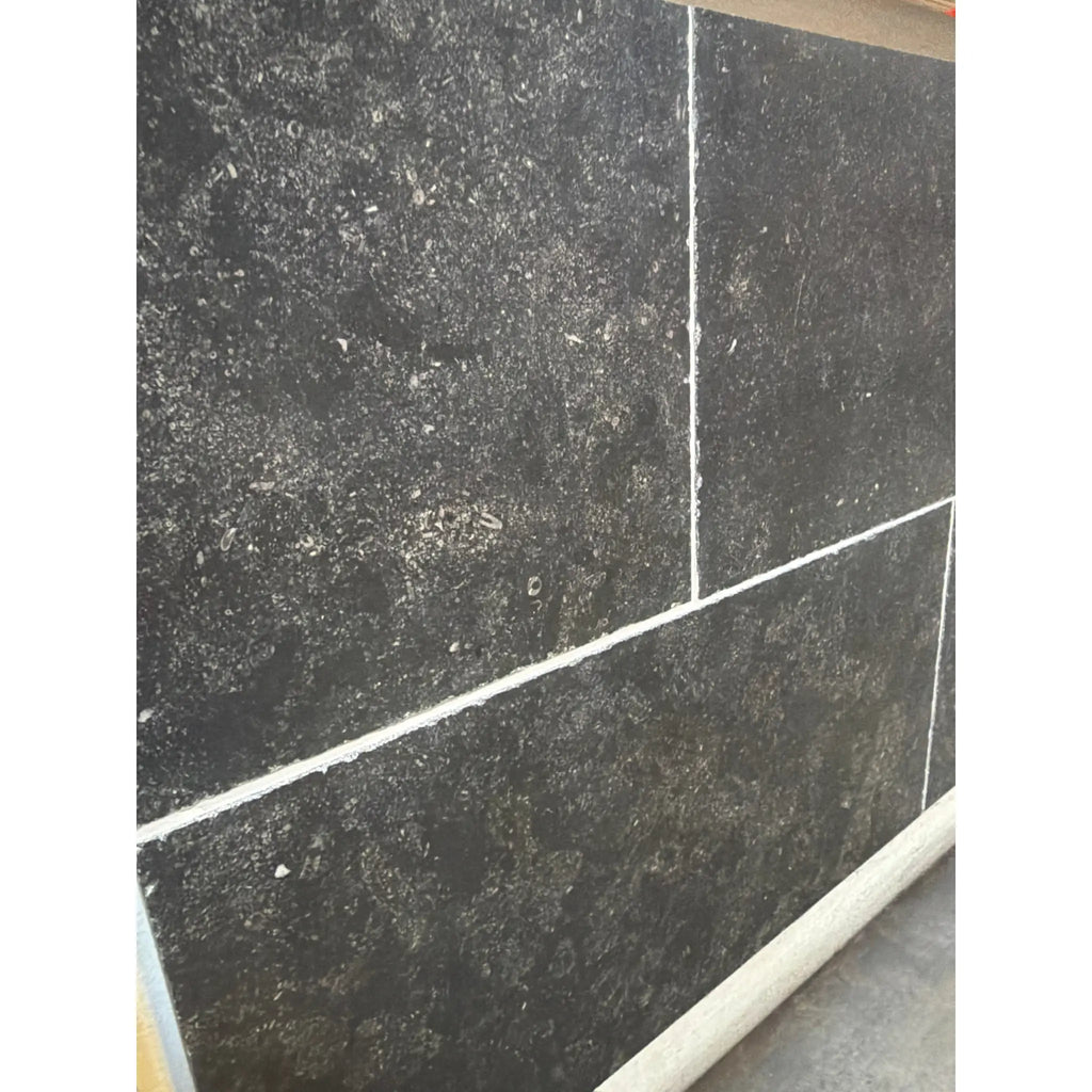 Obsidian Ash 16x24 honed limestone tiles in dark gray speckled texture with white grout
