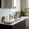 Modern white sink with sleek gold faucet on dark wood cabinet featuring oriental white marble 3x3 mosaic tile
