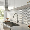 Modern chrome finished kitchen faucet with a sleek curved spout and pull down spray head in oriental white asian statuary marble mosaic