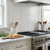 Oriental white asian statuary 1x2 herringbone marble mosaic polished tiles form a modern backsplash behind stainless stove