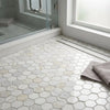 White hexagon marble mosaic tiles in oriental white asian statuary with subtle veining cover the bathroom floor