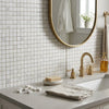 Gold-toned faucet with sleek modern design and three handles paired with oriental white asian statuary marble mosaic