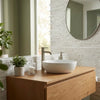 White ceramic vessel sink with sleek modern design on light wood vanity featuring oriental white asian statuary bamboo marble mosaic