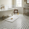 Oriental white asian statuary basketweave bath mat with plush texture and wooden brush on black marble mosaic surface