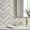 White marble mosaic tiles with gold-toned chevron patterns adorn the bathroom wall in oriental white asian statuary style