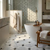 White freestanding bathtub with smooth curved edges next to oriental white asian statuary lattice marble mosaic panel
