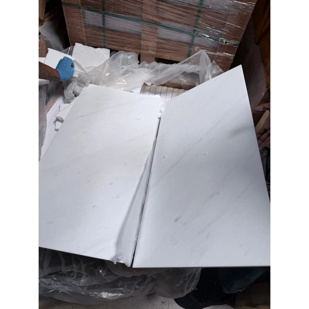 Oriental White Asian Statuary marble slabs in white with subtle gray veining neatly stacked and wrapped in plastic