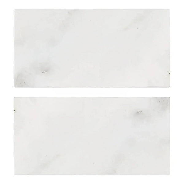 Two rectangular Oriental White Asian Statuary Marble 3X6 Tumbled tiles on display